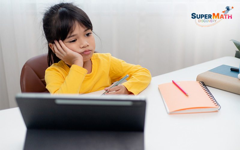 A young student looking bored while studying math.