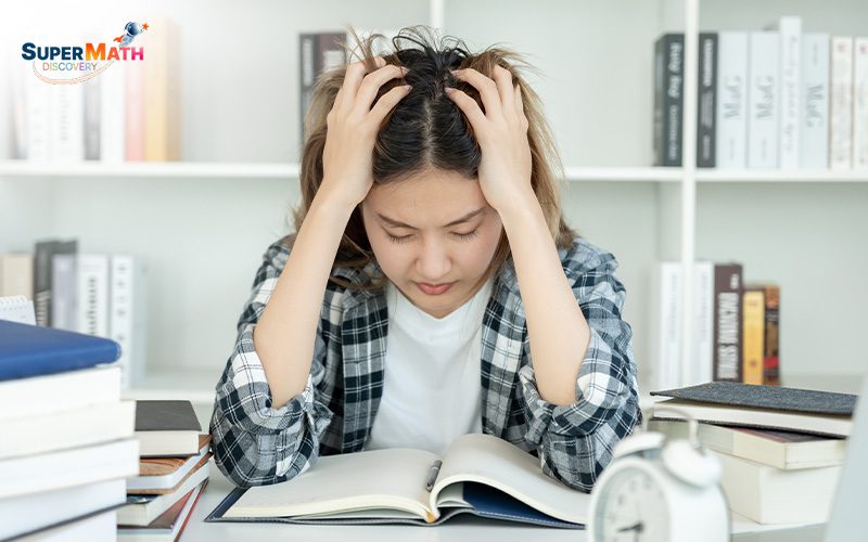 Student with hands on head, stressed about her math exams.