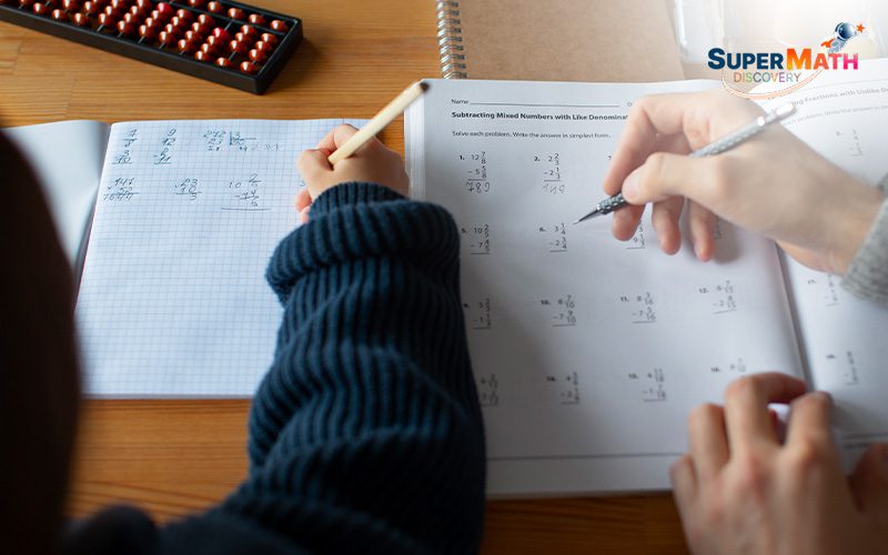 Teacher guiding a student on a maths worksheet.
